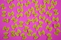High angle view on isolated many farfalle noodles on pink background