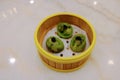 High angle view of isolated traditional dim sum spinach dumplings with caviar in bamboo steamer basket in restaurant selective Royalty Free Stock Photo