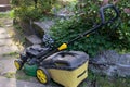 High angle view of lawnmower on stone path in small backyard. Royalty Free Stock Photo