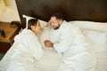 High angle view of a couple in love, newlyweds on their honeymoon. Beautiful woman lying in bed with her husband and enjoying the Royalty Free Stock Photo