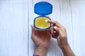 High angle view of man hand use white petroleum jelly