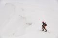 high angle view of man skier with trekking poles walking along snowy mountain slope Royalty Free Stock Photo