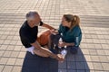 High angle view of mature couple in sportswear having a conversation while drinking water, relaxing outdoors on a sunny Royalty Free Stock Photo