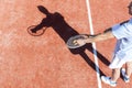 High angle view of mature man serving tennis ball on red court Royalty Free Stock Photo
