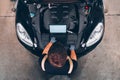 High angle view of mechanic examining car engine with help of laptop Royalty Free Stock Photo