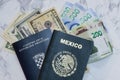 High angle view of A Mexican and Croatian Passports on dollars and pesos on the table