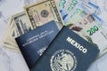 High angle view of A Mexican and Croatian Passports on dollars and pesos on the table