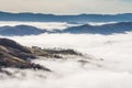 High angle view of mountaintops surrounded by clouds