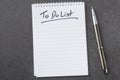 High angle view of a notepad with the to do list and a pen on grey desk Royalty Free Stock Photo