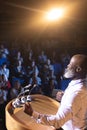 Businessman standing near podium and giving speech to the audience in the auditorium Royalty Free Stock Photo