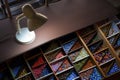 Top view of the old retro desk lamp with various colorful beads in wooden storage box on step table Royalty Free Stock Photo