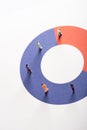 High angle view of people figures on red and blue round diagram on white surface