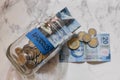 High angle view of pesos and coins in a jar with a [Ahorros - savings] sticker on it on the table Royalty Free Stock Photo