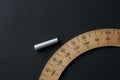 Piece of chalk and protractor on a chalkboard Royalty Free Stock Photo