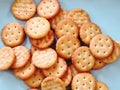 Pile of Crispy Thin Brown Crackers on Light Blue Plate