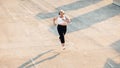 High angle view of plus size woman running outdoors. Young curvy female