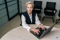 High-angle view portrait of elegance gray-haired middle-aged business woman using laptop computer sitting at workplace Royalty Free Stock Photo