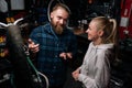 High-angle view of positive bearded cycling repairman male having conversation with smiling blonde female client Royalty Free Stock Photo