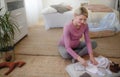 High angle view of pregnant woman looking at little clothes for her baby, packing them to maternity ward.