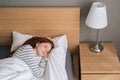 High-angle view of pretty redhead young woman sleeping well in bed hugging soft white blanket at home. Royalty Free Stock Photo