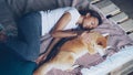 High angle view of pretty young woman in pajamas and her adorable puppy sleeping together on bed at home. Friendship Royalty Free Stock Photo