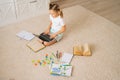 High-angle view of primary little child girl doing homework using laptop computer for distance education online sitting Royalty Free Stock Photo