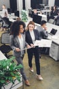 High angle view of professional young businesswomen holding papers and discussing project Royalty Free Stock Photo