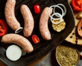 Raw pork sausages on grill pan with ingredients and spices Royalty Free Stock Photo