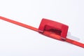 High angle view of red holepunch and paper strip on white background. Royalty Free Stock Photo