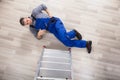 High Angle View Of A Repairman Fallen From Ladder Royalty Free Stock Photo