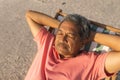 High angle view of retired senior biracial man sleeping with hands behind head on chair at beach