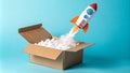 High-Angle View Rocket Launching from Cardboard Box, Blue Background Royalty Free Stock Photo