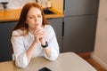 High-angle view of sad young woman praying with eyes closed holding folded hands in front of face at home. Royalty Free Stock Photo