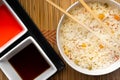 High angle view of sauces and a bowl of cooked rice with vegetables on the table Royalty Free Stock Photo