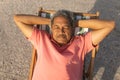 High angle view of senior biracial man sleeping with hands behind head on chair relaxing at beach Royalty Free Stock Photo