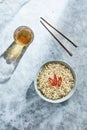 High angle view of served Asian food. Bowl with noodles decorated with slices of red chilli pepper on top and glass of drink. Royalty Free Stock Photo