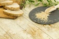 High angle view of a sliced loaf of sesame seeds homemade bread on wooden cutting board, sesame seeds on slate plate and an olive Royalty Free Stock Photo