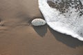 High angle view of stones on beach. Foam on a beach