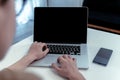 High angle view of student hands typing on laptop computer with blank black screen and smartphone on white table in bright living Royalty Free Stock Photo