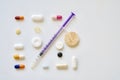 High angle view of a syringe needle and various pills on the table under the lights Royalty Free Stock Photo