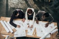 high angle view of team of architects working together with plans