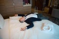 High angle view of tired businessman lying and sleeping on bed in hotel room Royalty Free Stock Photo