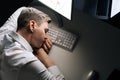 Top view of tired sleepy male employee asleep on computer desk late at night. Exhausted businessman sleeping with head Royalty Free Stock Photo