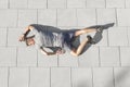 High angle view of tired sporty man lying on tiled sidewalk Royalty Free Stock Photo