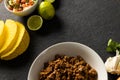 High angle view of tortillas with lemons, meat, garlic, tomato and onion in bowl on table