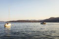 High angle view of a tour boat and a sail boat in Lake Orta, Italy, at sunset. Royalty Free Stock Photo