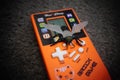 High-angle view of a toy bug over the orange Han Cheng brick game hand console