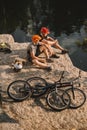 high angle view of trial bikers resting near logs cauldron and mountain cycles on rocky cliff Royalty Free Stock Photo