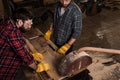 high angle view of two carpenters using machine saw