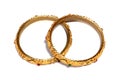 High angle view of two golden bracelets decorated with small stones isolated on a white background Royalty Free Stock Photo